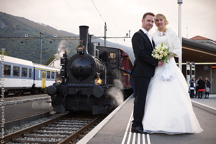 Hochzeitsfoto am Bahnhof Balsthal, Oensingen mit einer alten Dampflokomotive.
Foto von Hochzeitsfotografen Patrice Grünig