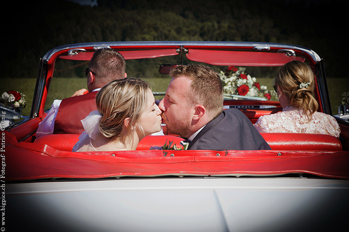 Kuss im Auto an der Hochzeit
